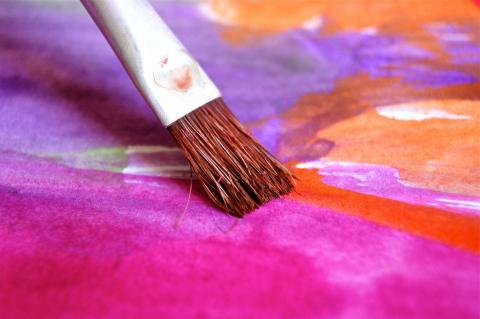 paintbrush on a brightly painted canvas