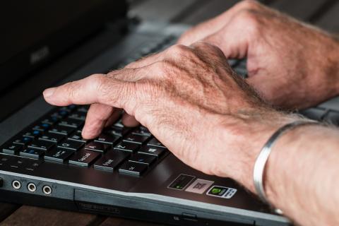 Hands typing on a laptop